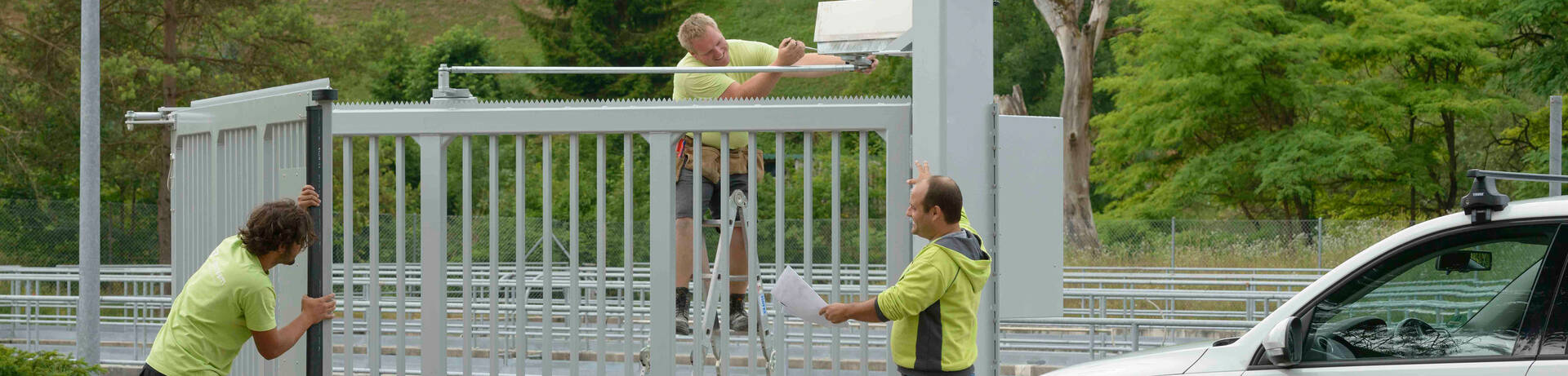 Zaunmonteure montieren einen Zaun, automatisches Schiebetor für einen Eingangsbereich in der Industrie | © Zaunteam
